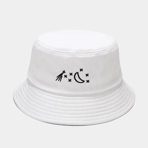 Close-up of white cotton canvas bucket hat featuring black star and moon embroidery detail