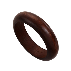 Macro detail of polished dark brown sandalwood bangle showing smooth wood grain texture