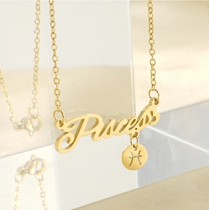 Detailed macro view of 18k gold Pisces zodiac pendant necklace with artistic lettering