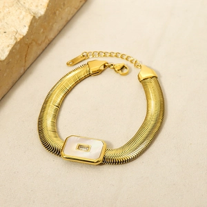 Detail of 18K gold plated snake chain bracelet featuring white shell and zircon
