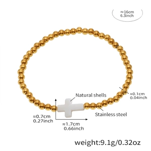 Detailed view of stainless steel gold beaded bracelet with natural shell cross pendant
