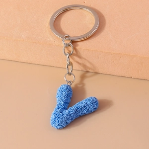 Detailed close-up of sky blue letter V keychain with 3D rose flower texture
