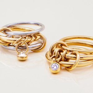 Luxurious multi-layer linked rings in gold and silver steel with cubic zirconia charms
