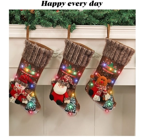 Detail of LED Christmas stockings with 3D snowman and Santa hanging on a white fireplace