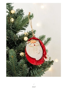 Detail of vintage tin Santa Claus ornament with rustic texture on a Christmas tree