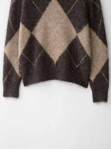 Gros plan détaillé d'un pull en maille avec motif à losanges et texture en mohair duveteux