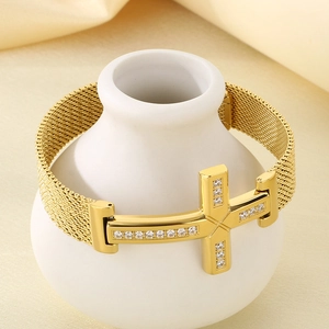 Close-up of golden stainless steel H-link bracelet with zircon stones on silk fabric
