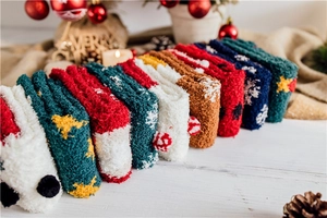 Close-up of soft coral fleece Christmas socks in various festive colors and patterns