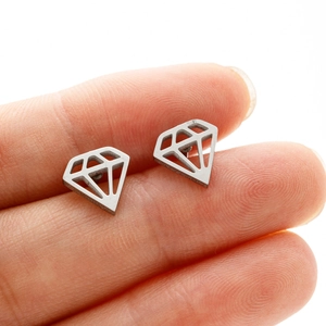 Macro detail of geometric diamond stud earring on a fingertip for size scale reference