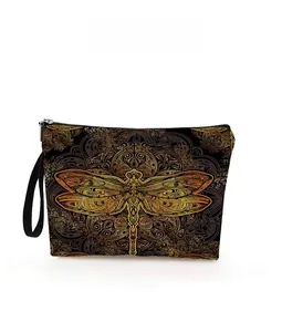 Detail view of black dragonfly makeup bag with golden mandala pattern and zipper strap