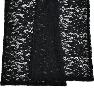 Detailaufnahme von schwarzem Spitzengewebe mit floralem Muster und Netzstruktur der Hose