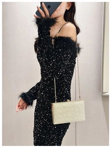 Chic gold acrylic evening box clutch bag held by model with elegant chain detail
