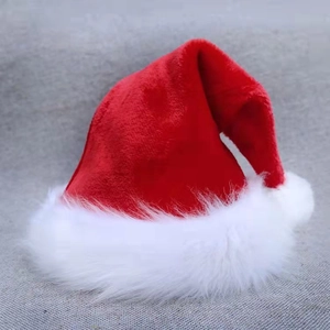 Close-up of a classic red plush Christmas hat with a fluffy white faux fur brim and pompom