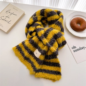 Detail of yellow and grey striped knit wool scarf with ins label on white surface