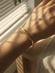 Detailed close-up of double-layered twisted gold snake chain bracelet on a wrist