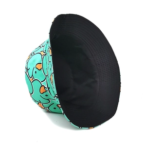 Detailed close-up of mint green bucket hat with yellow duck patterns and black lining