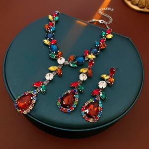 Close-up of vintage leaf and teardrop jewelry set with vibrant colorful crystals