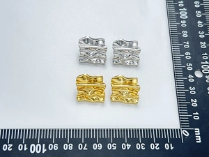 Macro detail of gold and silver square wavy earrings with 15mm scale measurement