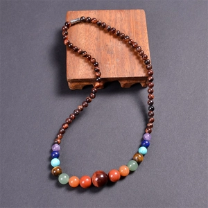 Macro shot of 6mm natural colorful agate and quartz beads on a brown wood base
