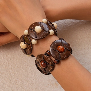 Gros plan de bracelets bohèmes en coque de noix de coco et perles de bois au poignet