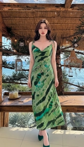 Dettaglio della spallina regolabile e dello scollo a drappeggio sull'abito midi in raso verde