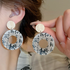 Close-up of bamboo and calligraphy patterns on hollow round resin drop earrings