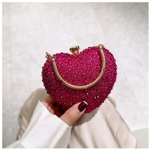 Close-up of heart-shaped evening bag with sparkling rhinestones and gold chain