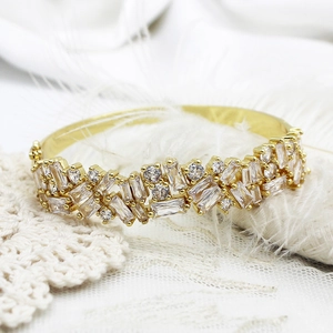 Macro shot of 18K gold plated bangle with micro-paved cubic zirconia on white lace