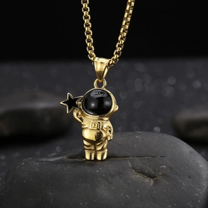 Detailed close-up of golden astronaut pendant with black star and box chain