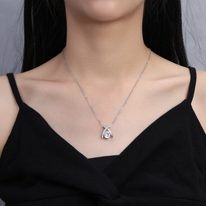 Macro detail of a 2ct round zircon pendant on a silver necklace worn by a model