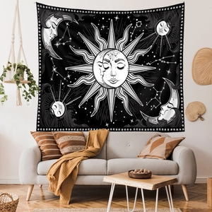 Detail of bohemian sun and moon tapestry hanging above a grey sofa in a cozy room