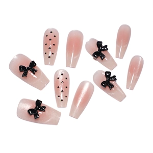 Nude pink gradient press-on nails with black dots and 3D bowknot in ballet style