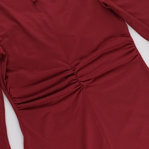 Détail de la texture froncée rouge foncé et du tissu élastique de la robe moulante