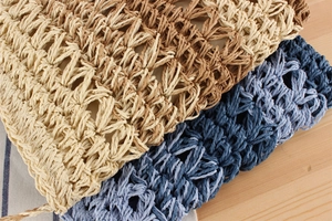 Detail of hand-woven gradient straw texture in beige brown and blue on wood background