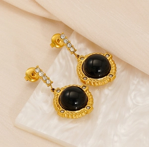 Détails de boucles d'oreilles vintage dorées avec pierres noires et strass brillants