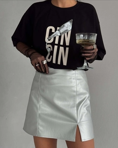 Détail du t-shirt noir graphique et de la mini-jupe argentée métallisée avec fente latérale