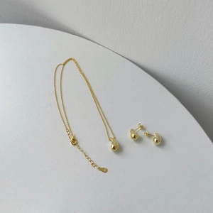 Detailed macro view of S925 sterling silver gold droplet necklace and earring set