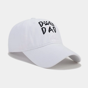Close-up of white cotton baseball cap featuring black DOG DAD embroidery with a paw print