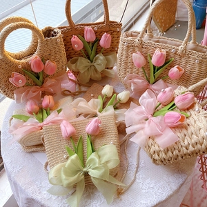 Detail of straw woven bags with organza bows, tulip floral accents and pearl straps