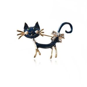 Detailed view of deep blue enamel cat brooch with green gem eyes and sparkling rhinestones