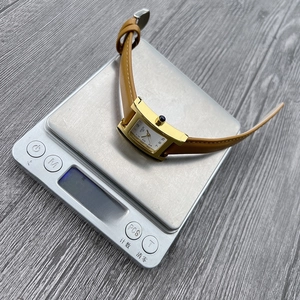 Macro shot of a vintage square quartz watch on a digital scale weighing exactly 31.0 grams