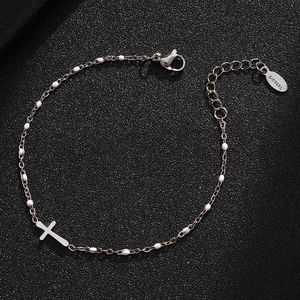 Detail view of silver stainless steel bracelet featuring cross pendant and white beads