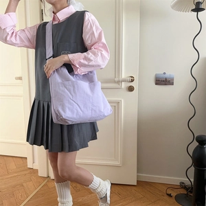 Dettaglio della grande borsa in tela lavanda con doppie tasche frontali e stile casual