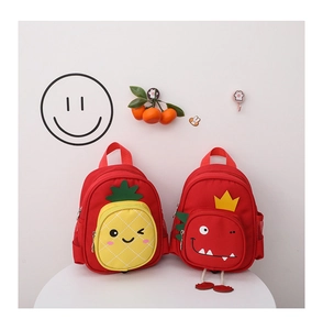 Close-up of cute red kids backpacks with pineapple and dinosaur cartoon designs