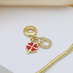 Golden four-leaf clover charm with red enamel and sparkling stones for charm bracelets