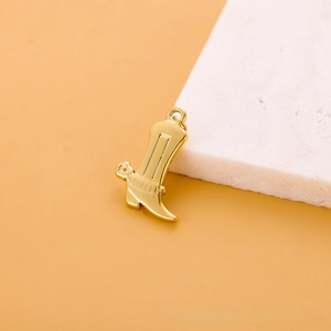 Détail d'un pendentif botte de cowboy dorée polie pour la création de bijoux DIY