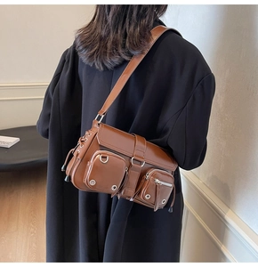 Detailed view of the multi-pocket leather handbag on a model in an oversized blazer