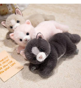 Detailed view of three soft plush Persian cat toys in grey and pink on a warm rug