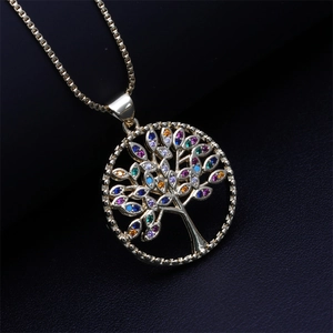Macro shot of golden tree of life pendant with colorful zircons on a black background