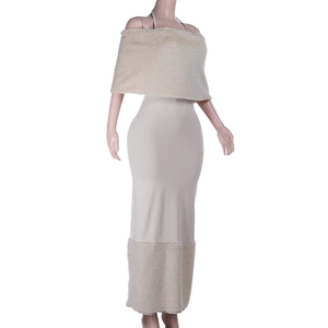 Dettaglio dell'abito in maglia beige con bordo in pelliccia e coprispalle coordinato